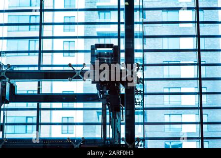 Glasaufzug, Geschäftsmann mit modernem Glasaufzug in die oberen Etagen, hohes Gebäude, Büro- und Einkaufszentrum und Hotel, Transport Stockfoto