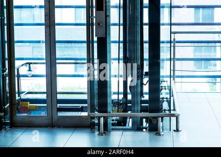 Glasaufzug, Geschäftsmann mit modernem Glasaufzug in die oberen Etagen, hohes Gebäude, Büro- und Einkaufszentrum und Hotel, Transport Stockfoto