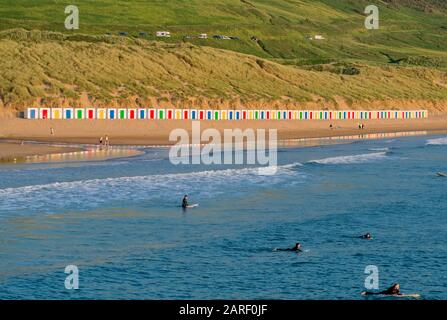 Saunton Sands Strand mit Sanddünen und einer Reihe von bunten, bemalten Strandhütten am Surfstrand in North Devon, Südwesten, Großbritannien Stockfoto