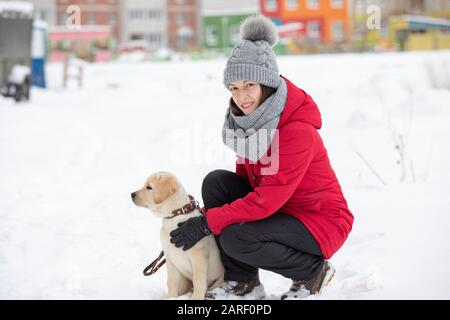 Junge schöne Frau Wandern im Schnee mit ihrem Hund auf verschneiten Wintertag. Stockfoto