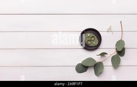 Komposition aus zwei goldenen Hochzeitsringen auf grünen Blättern Stockfoto