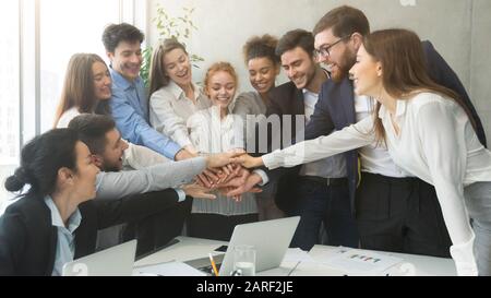 Teambuilding-Konzept. Fröhliche Kollegen, die sich mit den Händen verbinden Stockfoto