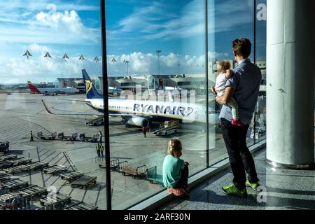 Wartende Familie am Flughafen, Mann und Kinder beobachten Flugzeuge auf der Landebahn Flughafen Palma de Mallorca Stockfoto