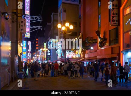 Osaka, JAPAN - 13. OKTOBER 2019: Die nächtliche Aussicht auf Menschen, die die Straße Dotonbori mit Neonlicht, extravaganter Beschilderung und der enormen heruntergehen Stockfoto