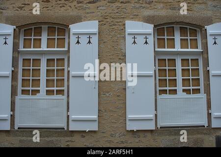 Zwei Fenster mit Jalousien im alten Stil an der Steinwand Stockfoto