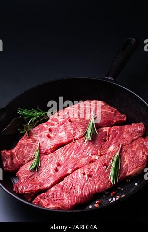 Lebensmittelkonzept Bio Rohfleisch Filet Beef Steak in Skillet Eisen-Pfanne auf schwarzem Hintergrund Stockfoto