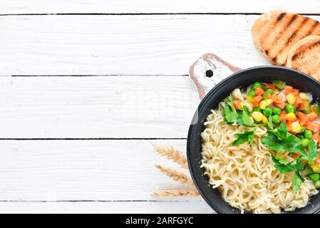 Asiatische Suppe mit Nudeln und Gemüse in einer Schüssel, mit Toastbrot. Diätetische Speisen. Draufsicht. Freier Speicherplatz. Stockfoto