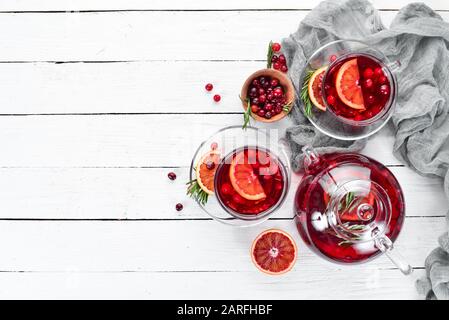 Heißes Getränk aus Preiselbeere und Orange in Tassen. Auf weißem Holzhintergrund. Draufsicht. Freier Speicherplatz für Ihren Text. Stockfoto