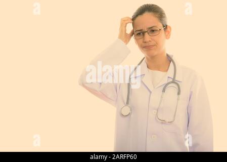 Studio shot der Jungen betonte Frau Doktor denken beim Kratzen Kopf Stockfoto