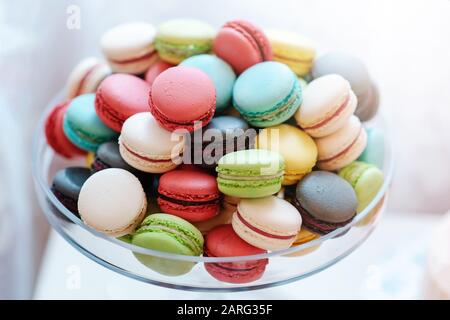 Eine große Auswahl an köstlichen und schönen kleinen Makronen in einer Glasvase. Sanfte Mandelkuchen in hellen Farben. Stockfoto