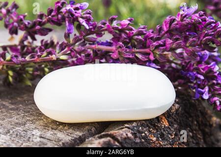 Handgefertigte Lavendelseife auf Holzgrund mit Lavendelwildblumen. Seife für das Gesicht. Körperpflege. Stockfoto