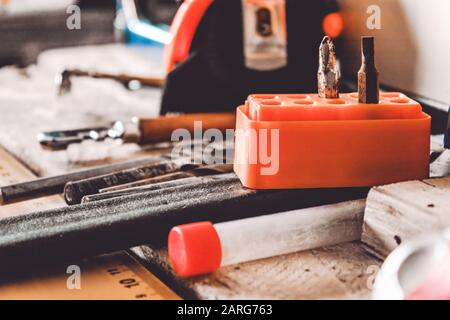 Auf dem Tisch liegen Werkzeuge für die Arbeit mit einem Schraubenschlüssel, einem Schraubendreher und einem Bohrer. Verschiedene Schreinwerkzeuge. Werkzeuge für den Job. Stockfoto