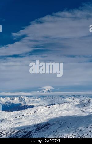 Blick über die alpen vom Gipfel der La Masse im französischen Skigebiet Les Menuires. Eine Lentikularwolke sitzt über einem fernen Gipfel Stockfoto