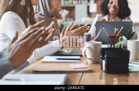 Mitarbeiter, die mehrere ethnische Gruppen haben, klatschen die Hände Stockfoto