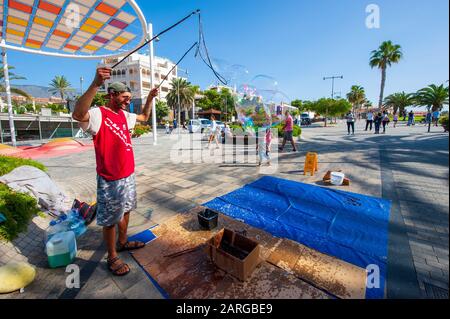 KANARENINSEL TENERA, SPANIEN - 27 DEC, 2019: Ein Blasenkünstler auf der plaza Duque. Es ist ein Boulevard mit Geschäften in der Nähe des beliebten Strandes Playa El Duque. Stockfoto