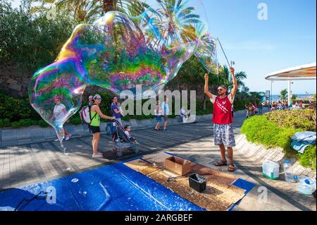 KANARENINSEL TENERA, SPANIEN - 27 DEC, 2019: Ein Blasenkünstler auf der plaza Duque. Es ist ein Boulevard mit Geschäften in der Nähe des beliebten Strandes Playa El Duque. Stockfoto