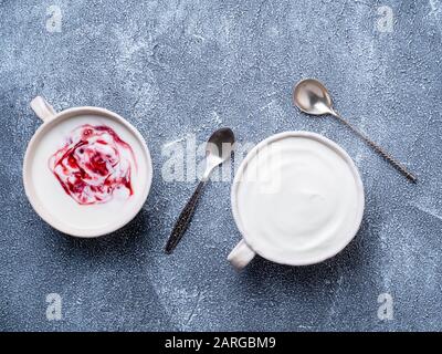 Zwei griechische Joghurt in weißer Schüssel auf graublauem Betonsteintisch, Draufsicht Stockfoto