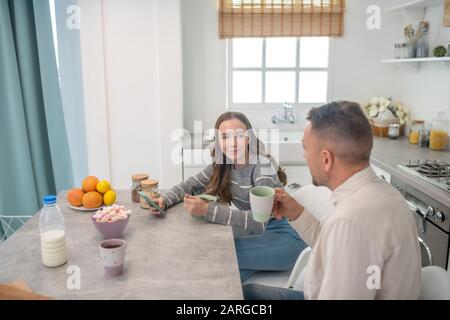 Vater und Tochter sprechen nach dem Frühstück am Tisch. Stockfoto