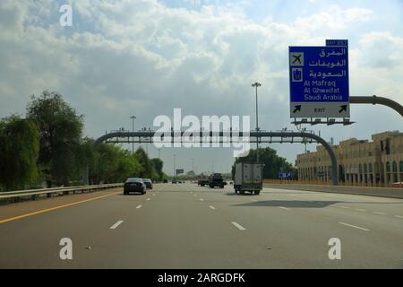 Dubai, VAE - 19. November 2019: Auf der modernen Autobahn zwischen Dubai und Abu Dhabi ist ein Straßenschild in arabischer und englischer Sprache gerichtet. Stockfoto