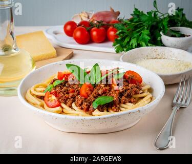 Nudelbolognese mit Tomatensauce, gemahlenes Hackfleisch, Basilikumblätter auf dem Hintergrund Stockfoto