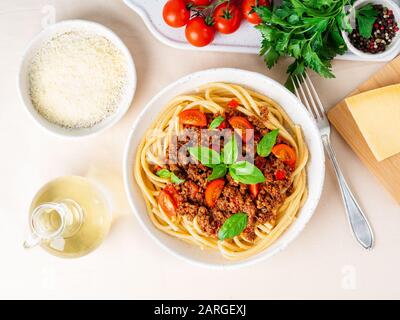 Nudelbolognese mit Tomatensauce, gemahlenes Hackfleisch, Basilikumblätter auf dem Hintergrund Stockfoto