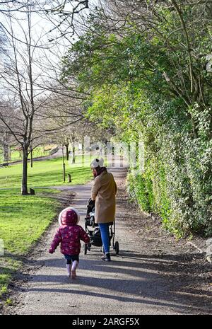 Brighton UK 28. Januar 2020 - EINE junge Mutter und ihre Kinder genießen einen Spaziergang durch den Queens Park in Brighton an einem schönen sonnigen, aber kalten Tag in Großbritannien. Kredit: Simon Dack / Alamy Live News Stockfoto