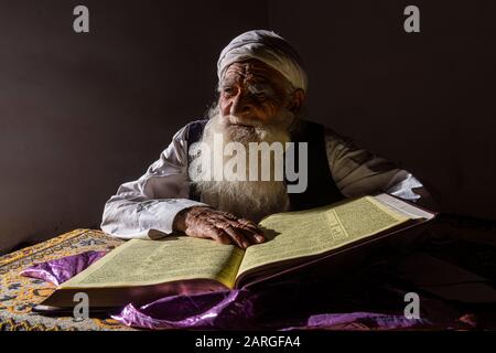 Sufi-Priester, der den heiligen Quran im Heiligtum von Mawlana Abdur Rahman Jami studiert, Herats größter Dichter aus dem 15. Jahrhundert, Herat, Afghanistan, Asien Stockfoto