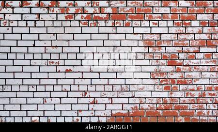 Schäbige Ziegelwand mit weißer Farbe angefärbt Stockfoto