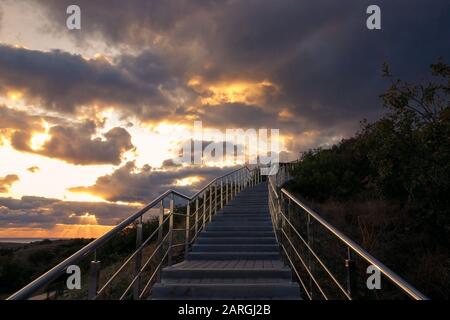 Treppe mit Metallgeländer, die zum Gewitterhimmel führt Stockfoto