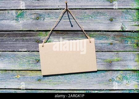 Naturholzkulisse, braune leere Pappkartons hängen am Seil. Mockup, horizontal. Stockfoto