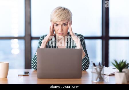 Überarbeitetes Business Woman Mit Kopfschmerzen Im Modernen Büro Sitzen Stockfoto