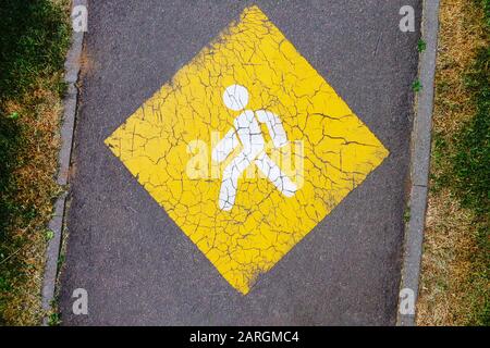 Gelbes Vorzeichen für Fußgänger auf Asphalt-Fußweg Stockfoto