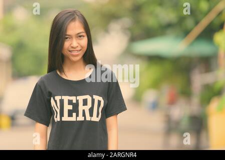 Junge glücklich Asiatischen Teenager nerd Mädchen lächelnd im Freien Stockfoto