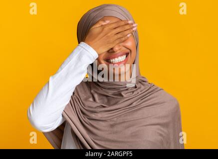 Facepalm. Fröhliche Schwarze Moslemfrau Im Kopftuch, Die Die Augen Mit Der Hand Bedeckt Stockfoto