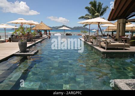 Poolbereich auf der Außenterrasse mit Liegestühlen, 5-Sterne-Hotel Domaine de L'Orangeraie, La Digue, Seychellen. Stockfoto