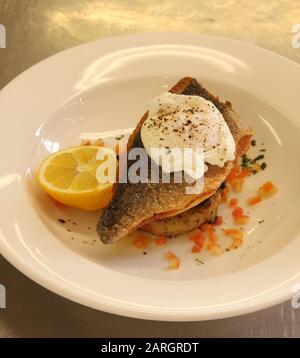 Gekochter Seabass mit einem pochierten Ei Stockfoto