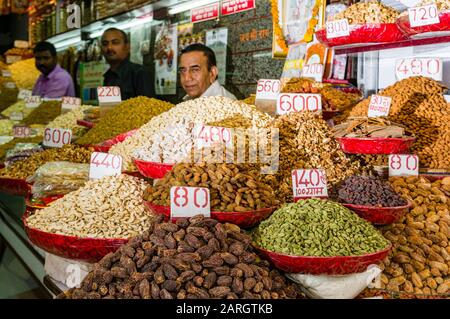 Ein Verkäufer verkauft in seinem Geschäft auf dem Gewürzmarkt in Alt-Delhi Nüsse und viele verschiedene Gewürze Stockfoto