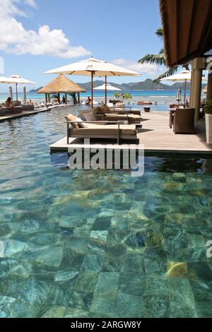 Poolbereich auf der Außenterrasse mit Liegestühlen, 5-Sterne-Hotel Domaine de L'Orangeraie, La Digue, Seychellen. Stockfoto