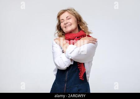 Lustig, reife Frau umarmen sich egoistisch. Studio shot Stockfoto