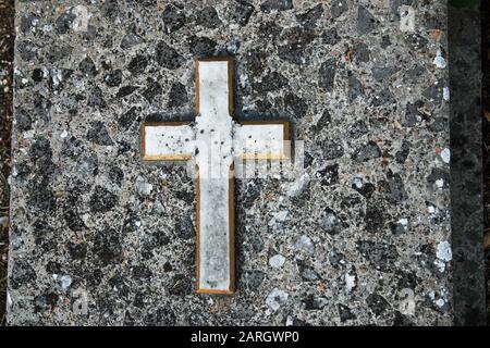 Alter Grabstein aus Granit mit Kreuz auf dem Friedhof Stockfoto
