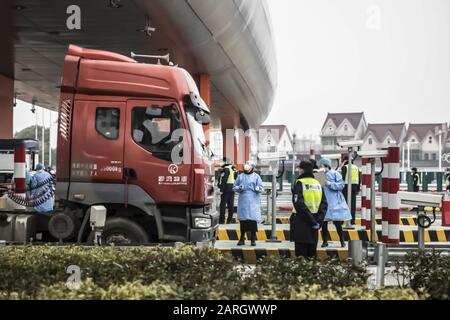 Shanghai, China. Januar 2020. Ein maskierter Gesundheitsfachmann und Polizeibeamte überprüfen den Fahrer eines Fahrzeugs an einem Kontrollpunkt auf einer Mautstation auf der Autobahn am Stadtrand von Shanghai. Regierungen, globale Unternehmen und internationale Gesundheitsorganisationen stürzten auf die Verbreitung eines SARS-ähnlichen Coronavirus, das mehr als 100 Leben in China forderte, Credit: Qilai Shen / Alamy Live News Stockfoto