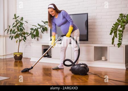 Schöne schwangere Frau putzt gern ihr Haus. Stockfoto