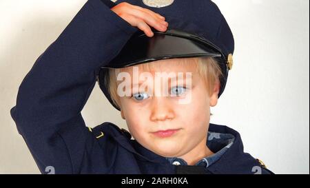 Sechs Jahre Alter Junge, Der Polizeibeamte Fancy Kleid Outfit Trägt, Salutierend Stockfoto