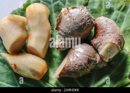 Nahaufnahme der geschälten und ungeschälten frischen Ingwerwurzel in einem Blatt Stockfoto