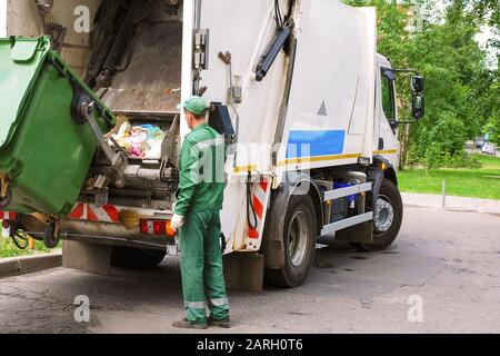 Müllsammelarbeiter, die die Strecke des Müllkompressors in Wohngebieten betreiben. Stockfoto