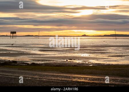 Morgendämmerung an der Northumbrian Coast, Blick über die Gezeitenwälle in Richtung Bamburgh Castle England, Großbritannien, GB. Stockfoto