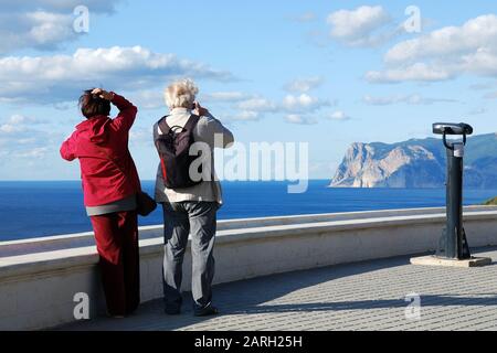 Ältere Paare machen Bilder von schöner See- und Berglandschaft, Rückblick. Aktives Alter, Reisen, Leben genießen. Stockfoto
