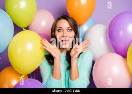 Foto von hübschen Händen der Dame, die in der Nähe von Wangen aufgezogen wurden, umgab viele bunte Luftballons, die am Freitag die Öffnung in Schwarz ankündigten, tragen pastellfarbenen Fuzzy-Pullo Stockfoto