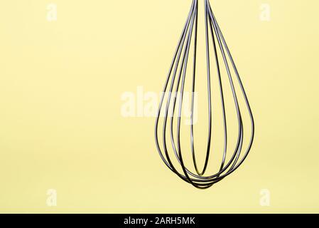 Edelstahl, Ballon-Handschaufel, isoliert auf cremefarbenem Hintergrund. Stockfoto