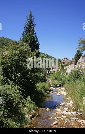 Der kleine Bach passiert das hübsche Dorf Termes in Les Corbières, Aude, Occitanie, Frankreich Stockfoto